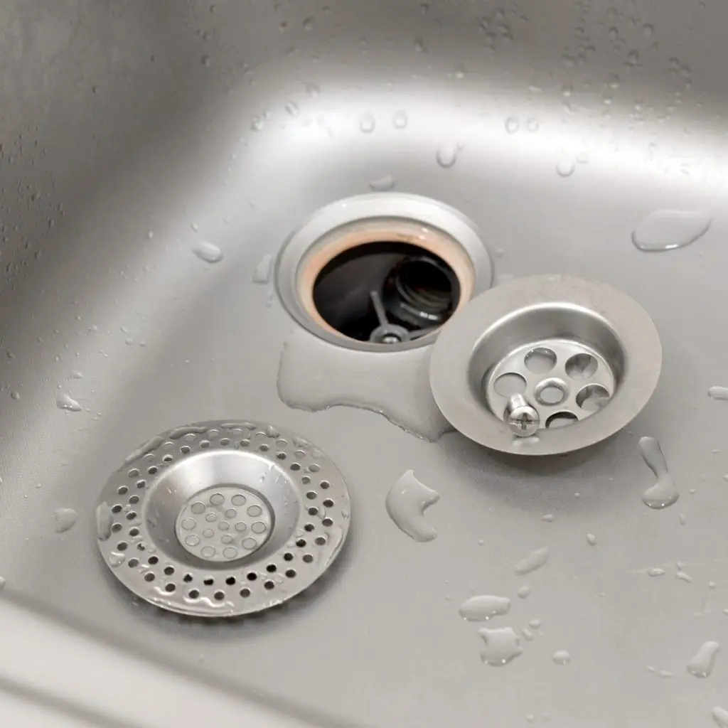 Silvery kitchen sink with a disassembled protective filter. Kitchen sink repair process